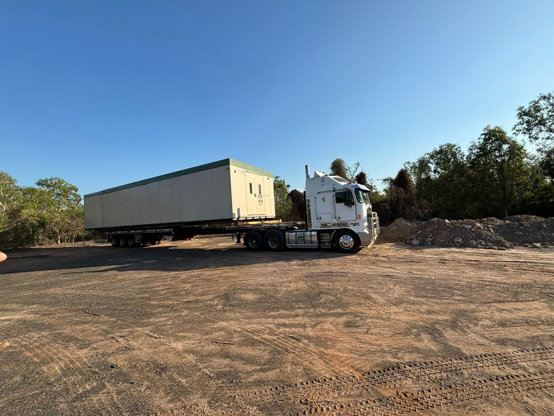 A Semi Truck is Driving Down the Road With a Trailer Full of Containers — Northern Franna Cranes NT in Mcarthur River, NT