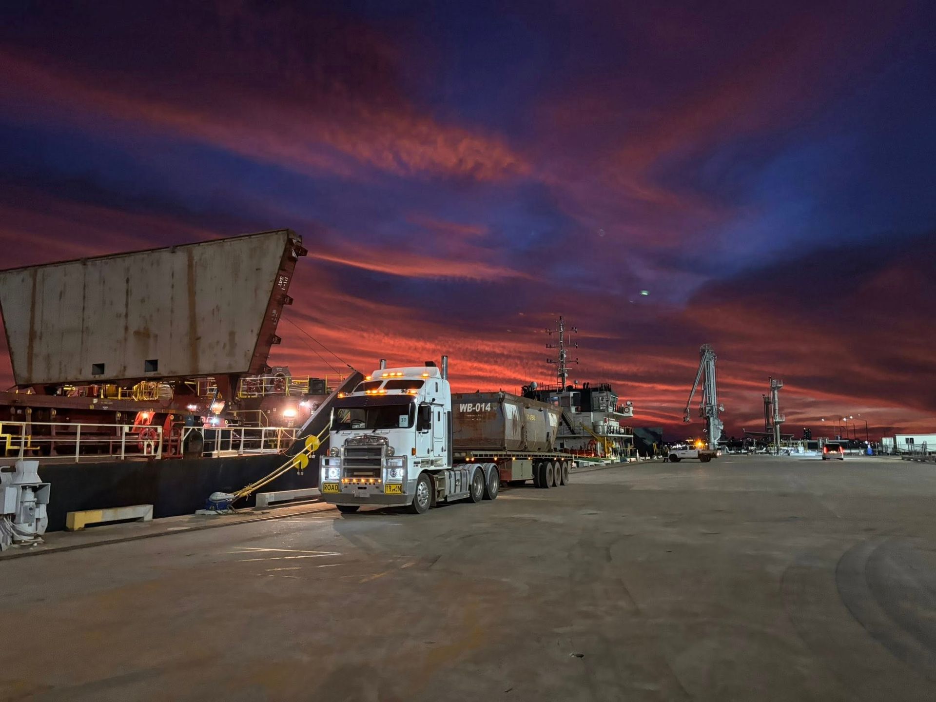 A truck is parked at a harbour and the sun is setting — Northern Franna Cranes NT in Katherine, NT