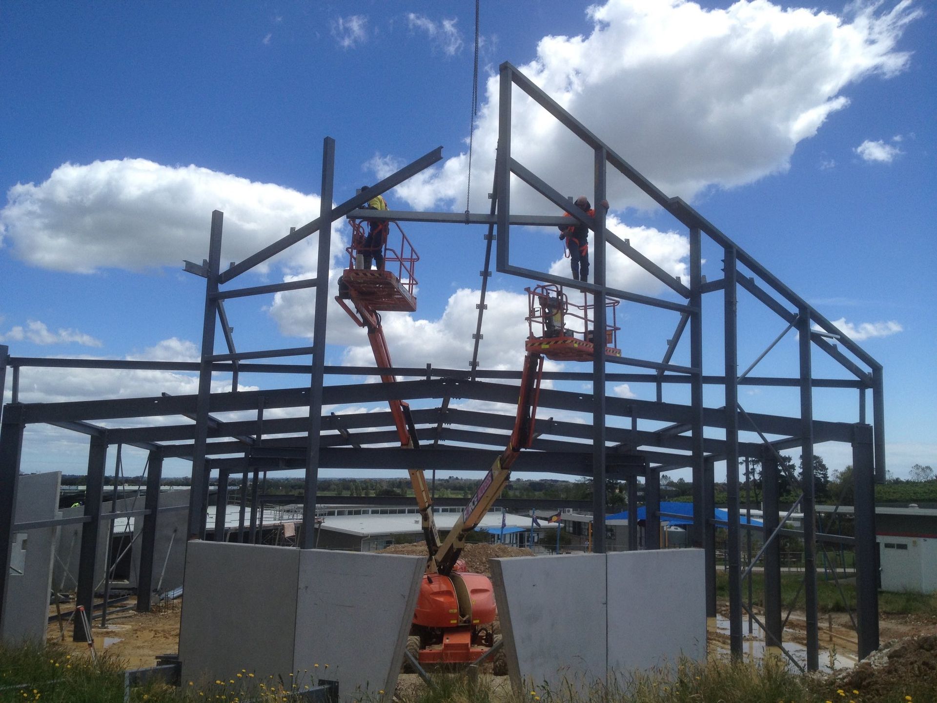 Two men are lifting in a crane working on a house — Northern Franna Cranes NT in Noonamah, NT