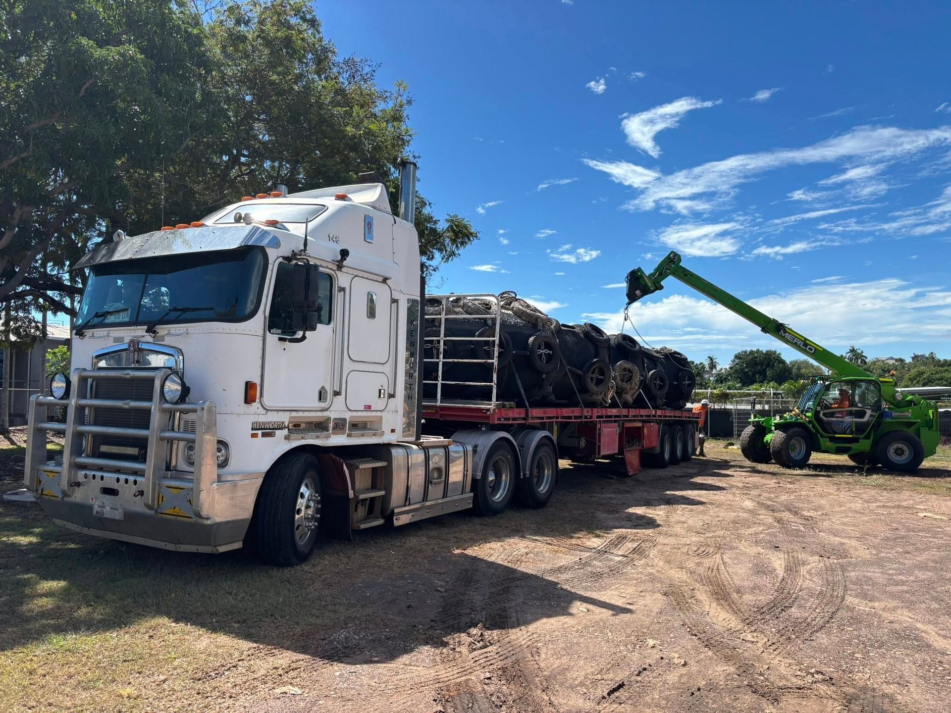 A Large White Truck Is Parked and A Green Crane Is Lifting Materials on The Trailer — Northern Franna Cranes NT in Noonamah, NT