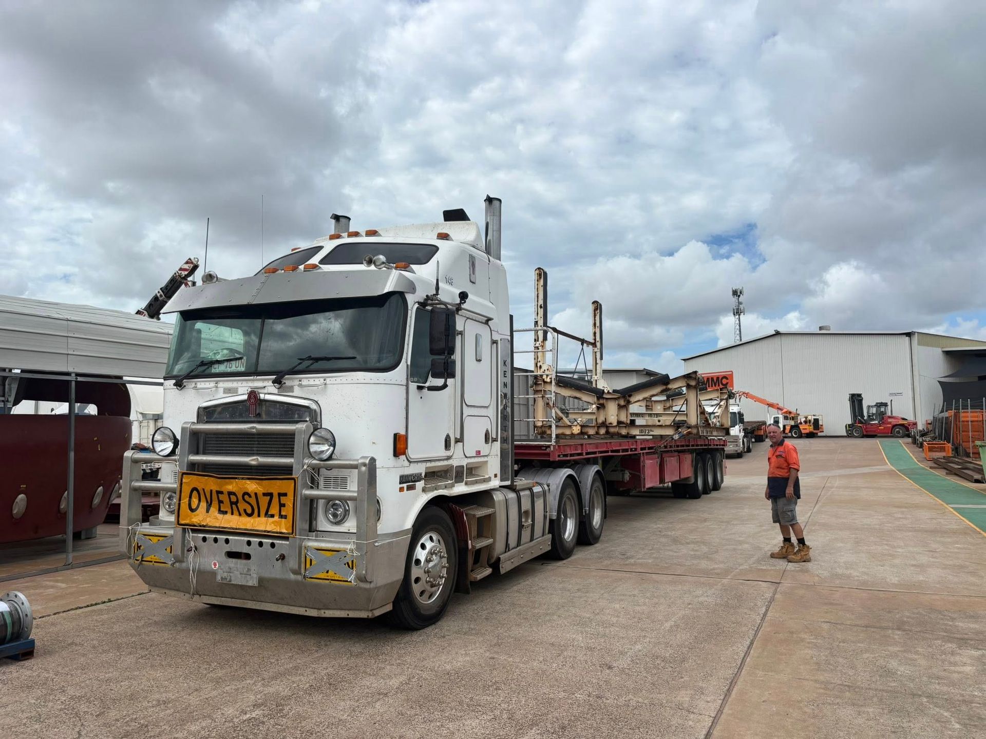 A Man Is Standing Next to A White Oversize Truck with A Crane Attached to It— Northern Franna Cranes NT in Noonamah, NT