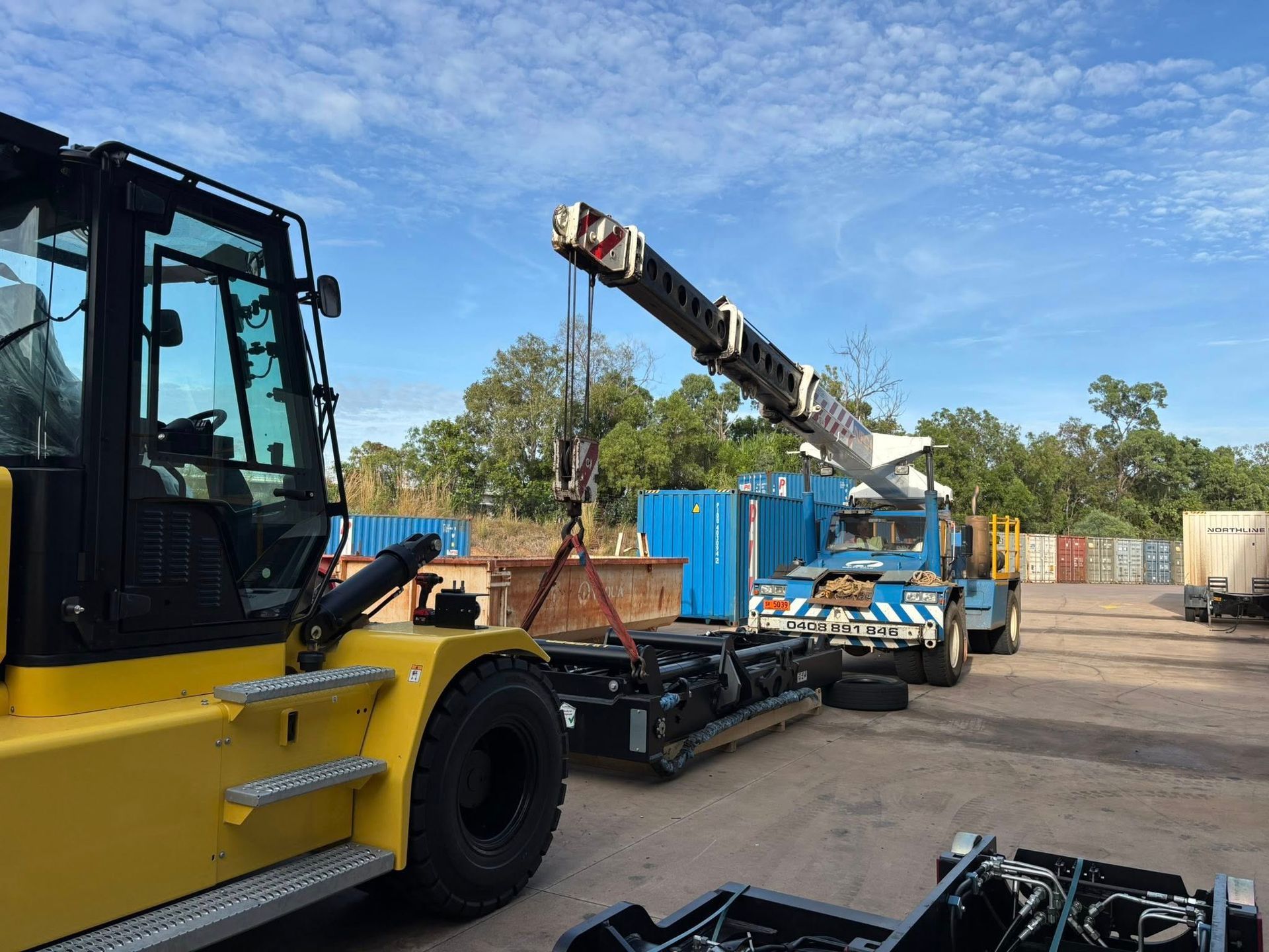 Image of a crane about to lift construction materials.