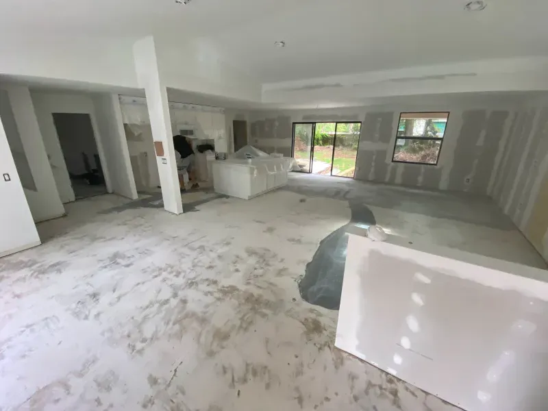 A room under construction with exposed drywall and flooring.