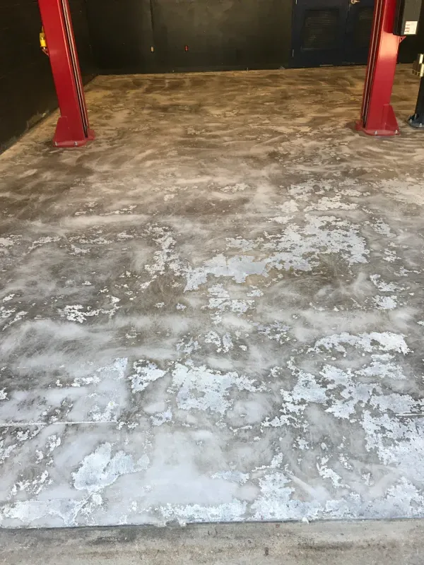 Flaking, gray-painted concrete floor in an auto repair shop.