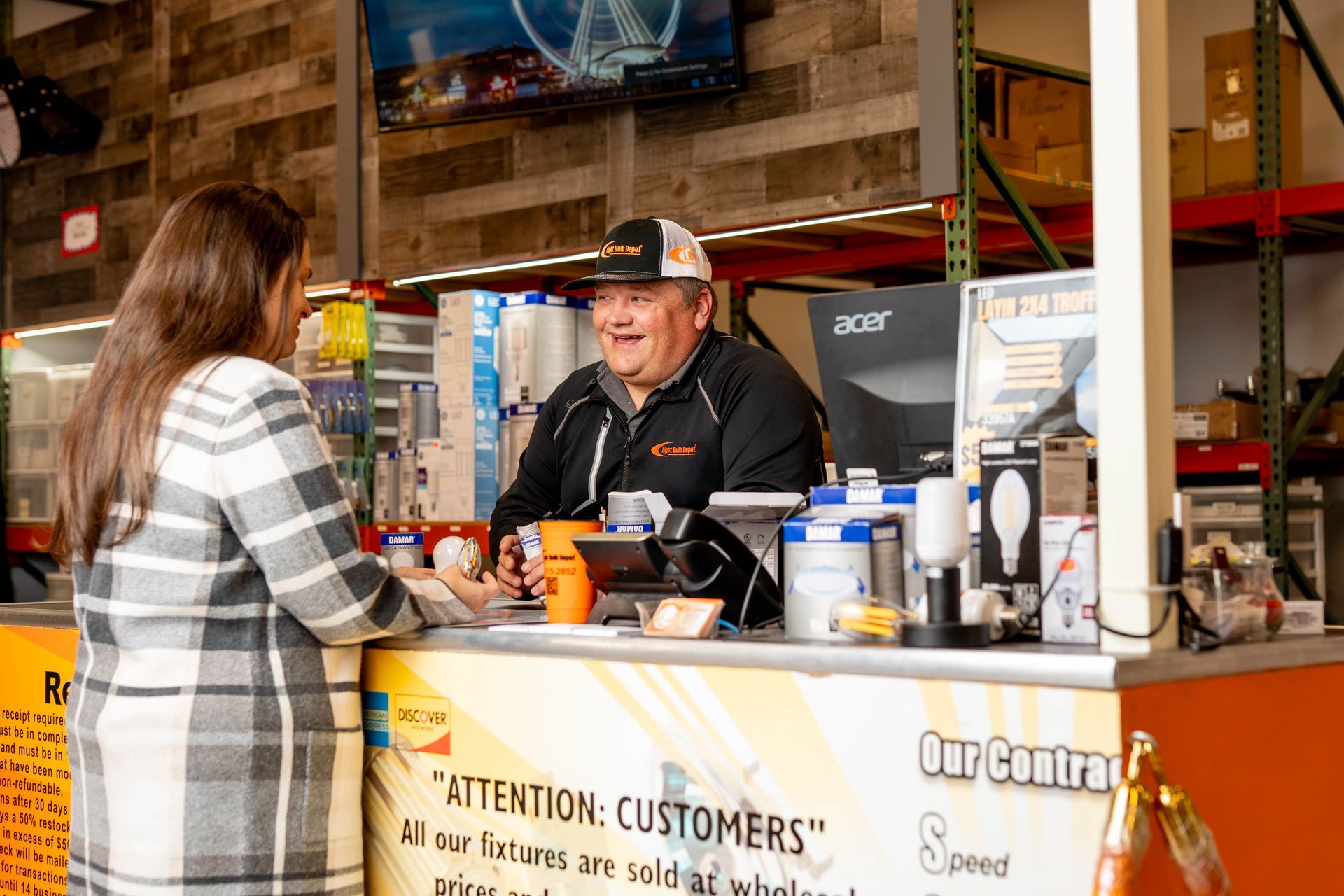 Customer speaking with lighting specialist at Light Bulb Depot store counter