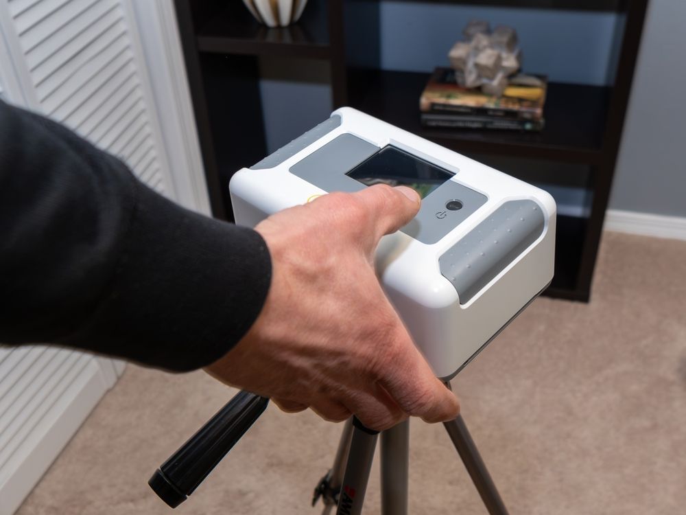 Home inspector doing a radon test setup in the lowest bedroom of a home