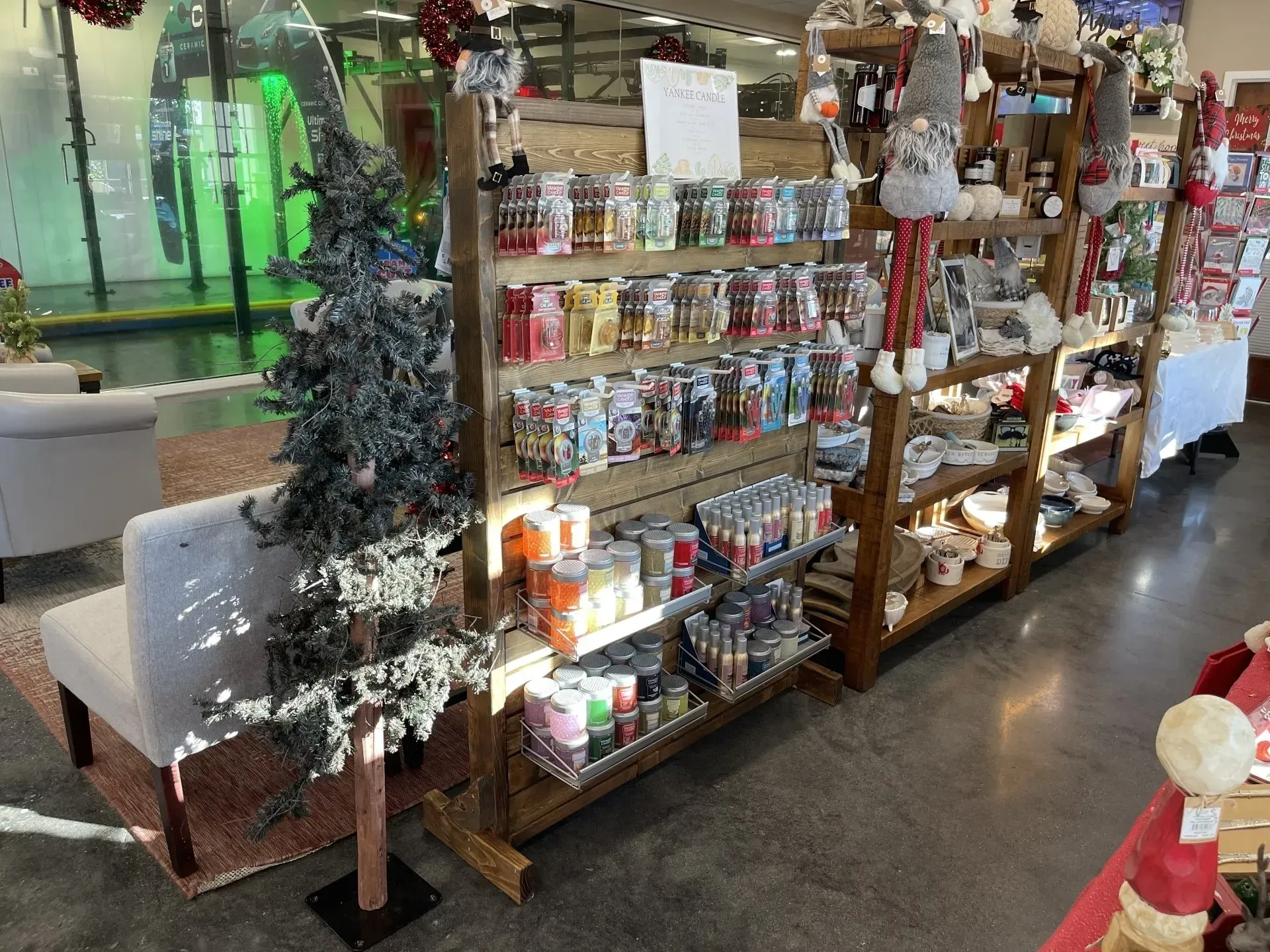 Shelves filled with Christmas items in a store. A small Christmas tree and a bench are in the foreground.