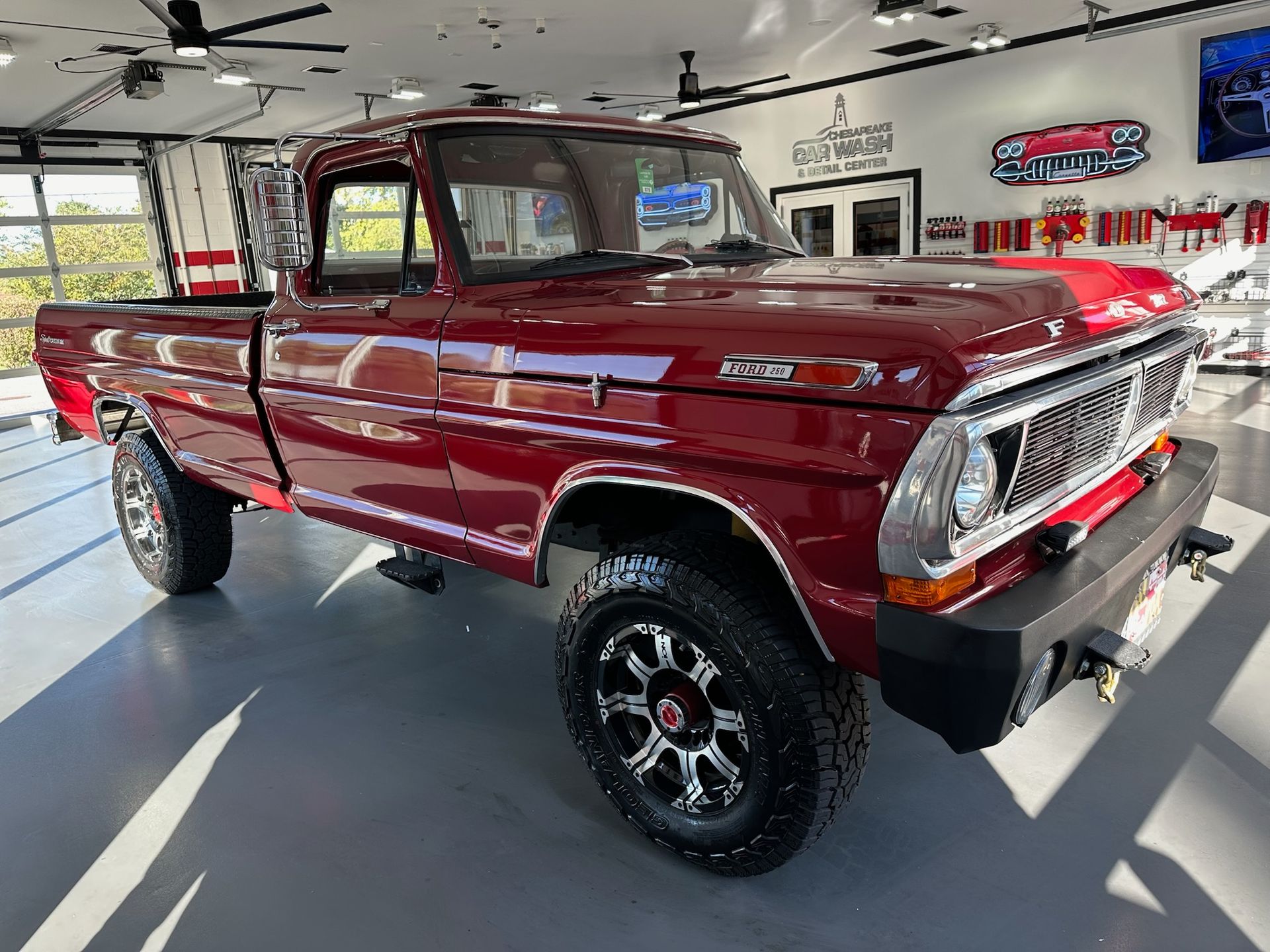 Classic red pickup truck displayed in a showroom with a polished floor and bright lights