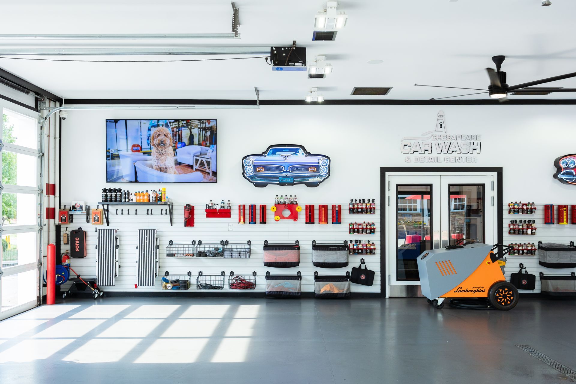 Auto repair shop interior with tools, car parts, and an orange motorcycle lift