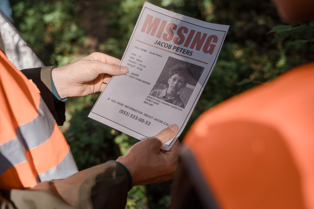 Two people in orange vests hold a 