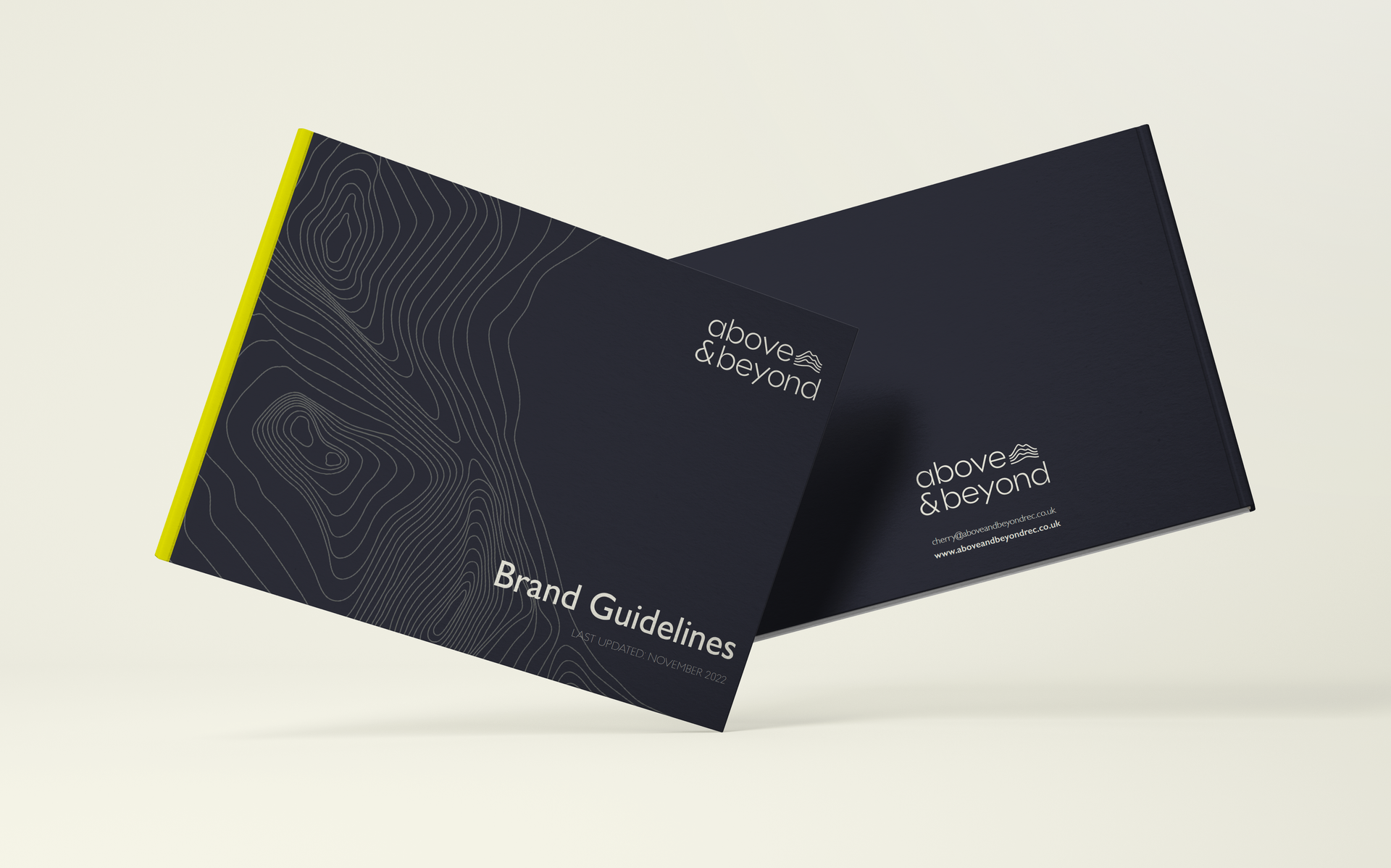 A front and back cover of a brand guidelines booklet for above and beyond in navy blue with a neon yellow spine.