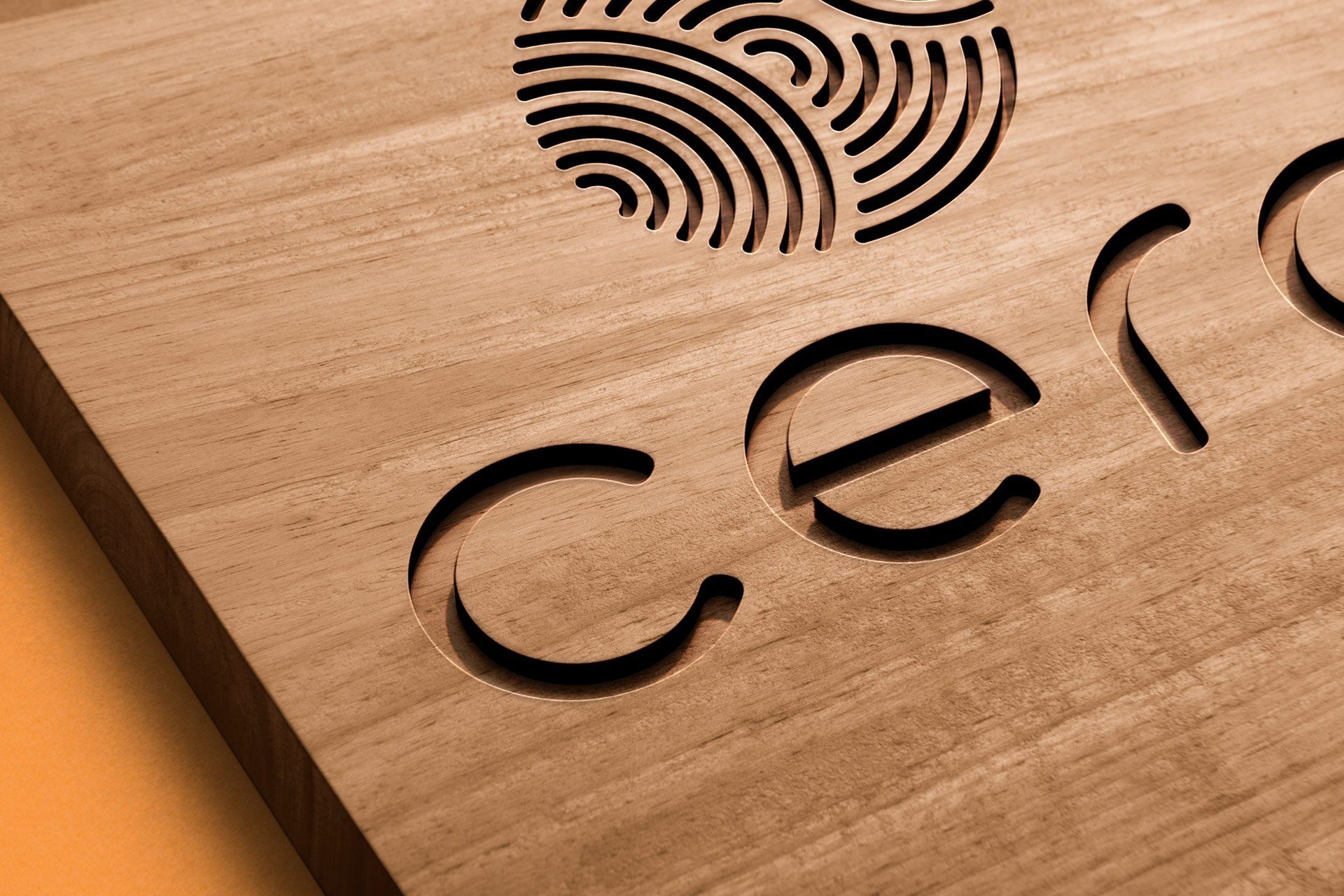 Close up of three-quarters of the cero logo cut into wood.