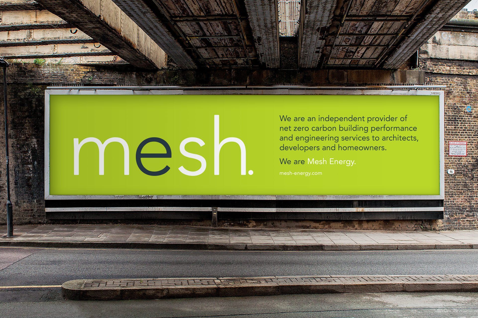 A large billboard set against a brick wall features the mesh logo and a description of the brand and its purpose.