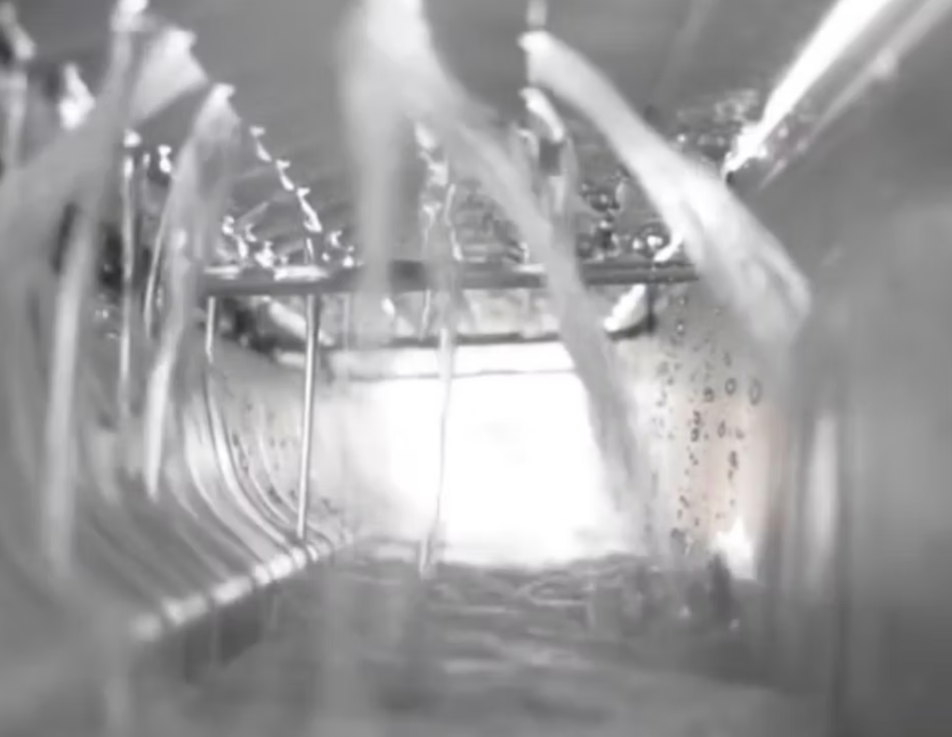 A black and white photo of a dishwasher filled with water.