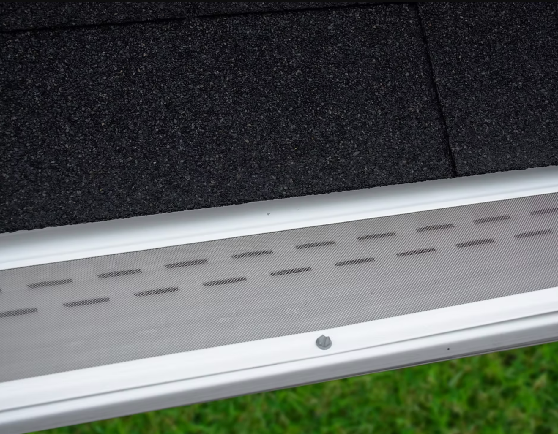A close up of a gutter with a screen on it.