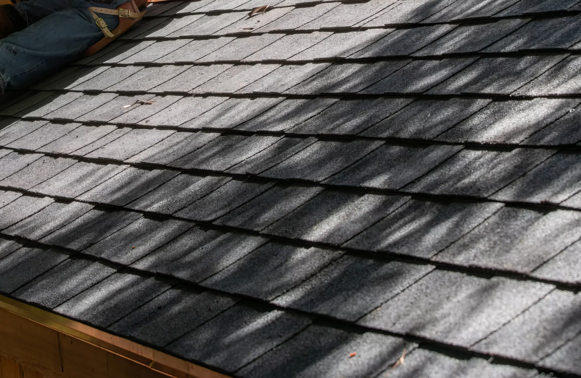 A close up of a roof with a shadow of a tree on it.