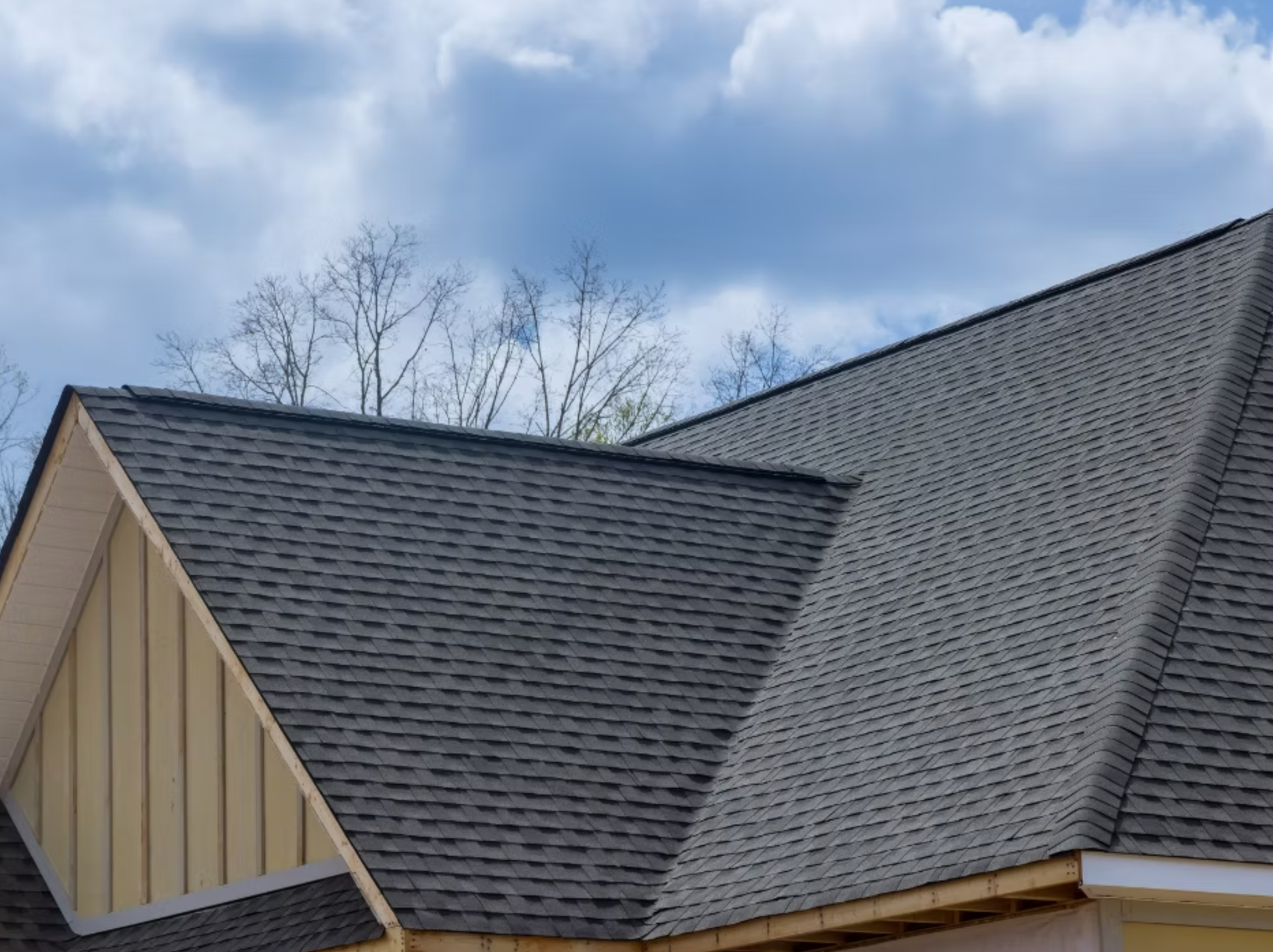 A close up of a roof of a house with a blue sky in the background.