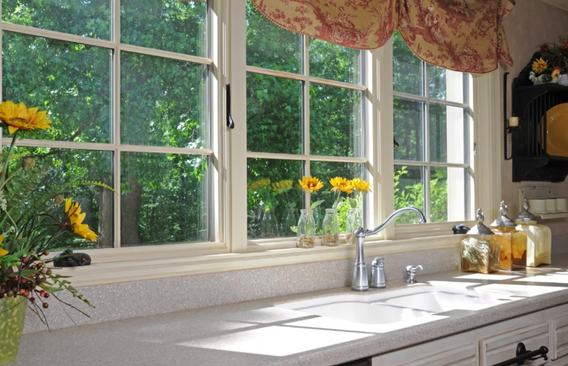 A kitchen with a sink and a window with flowers on it