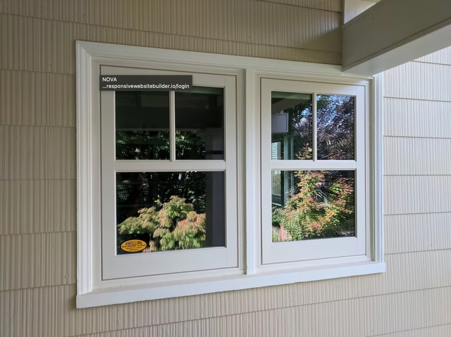 A white window is on the side of a house.