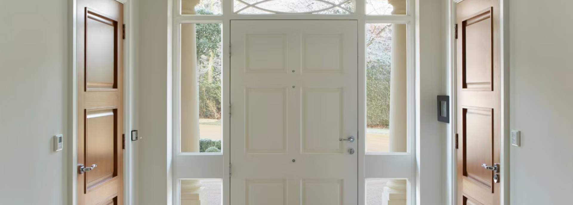 A hallway with a white door and wooden doors