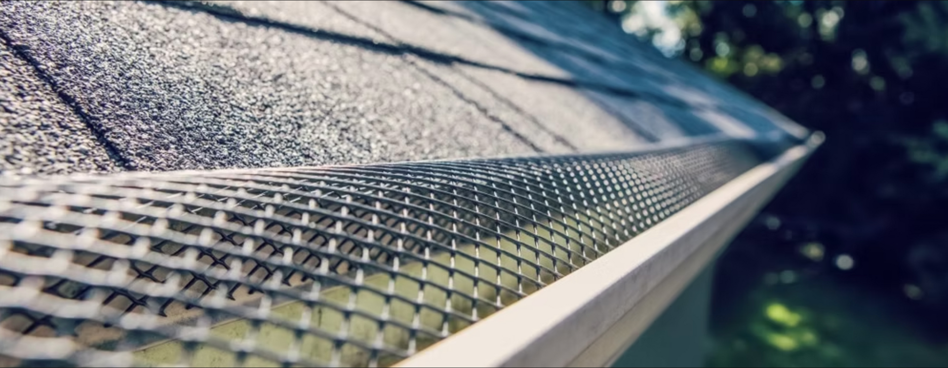 A close up of a gutter with a gutter guard on it.