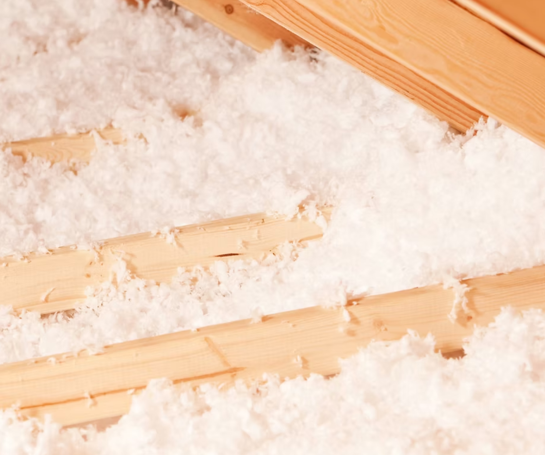 A close up of a wooden floor with white insulation on it.