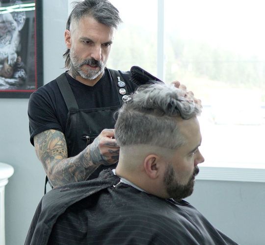 Action shot of Mike, a barber at Deluxe Barbershop in CDA