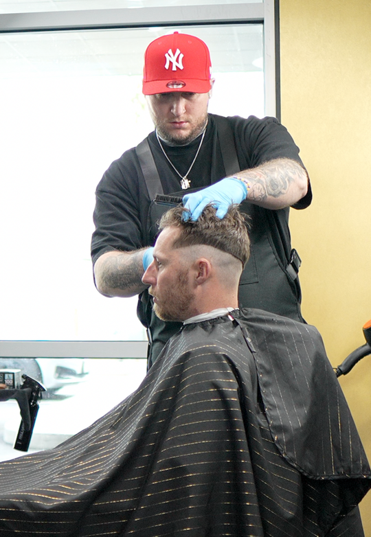 Action shot of Justice, a barber at Deluxe Barbership, in CDA