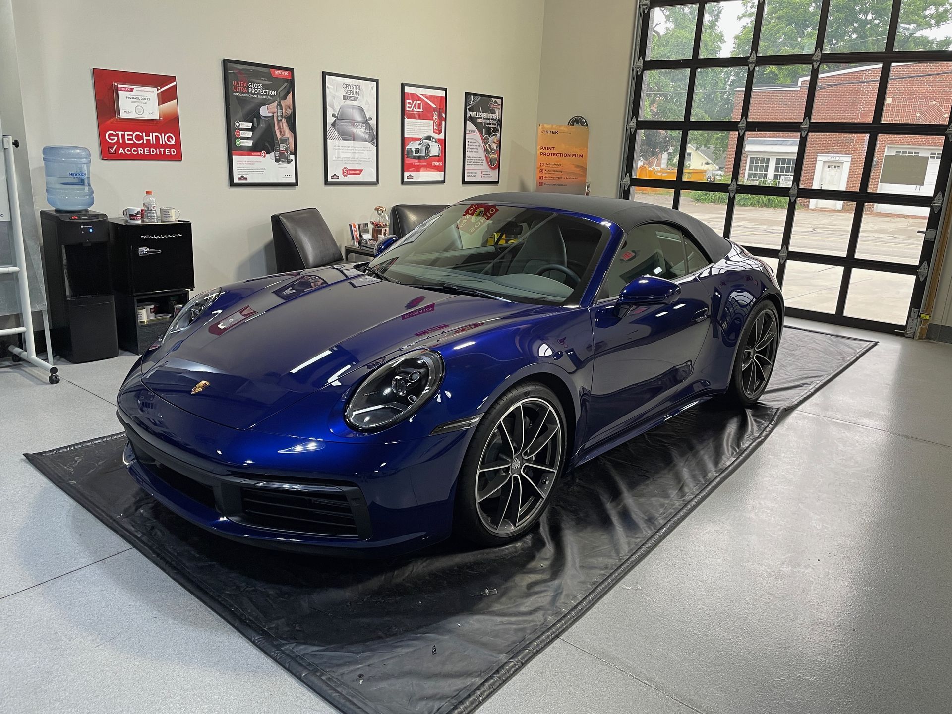 Blue Porsche convertible in a garage.