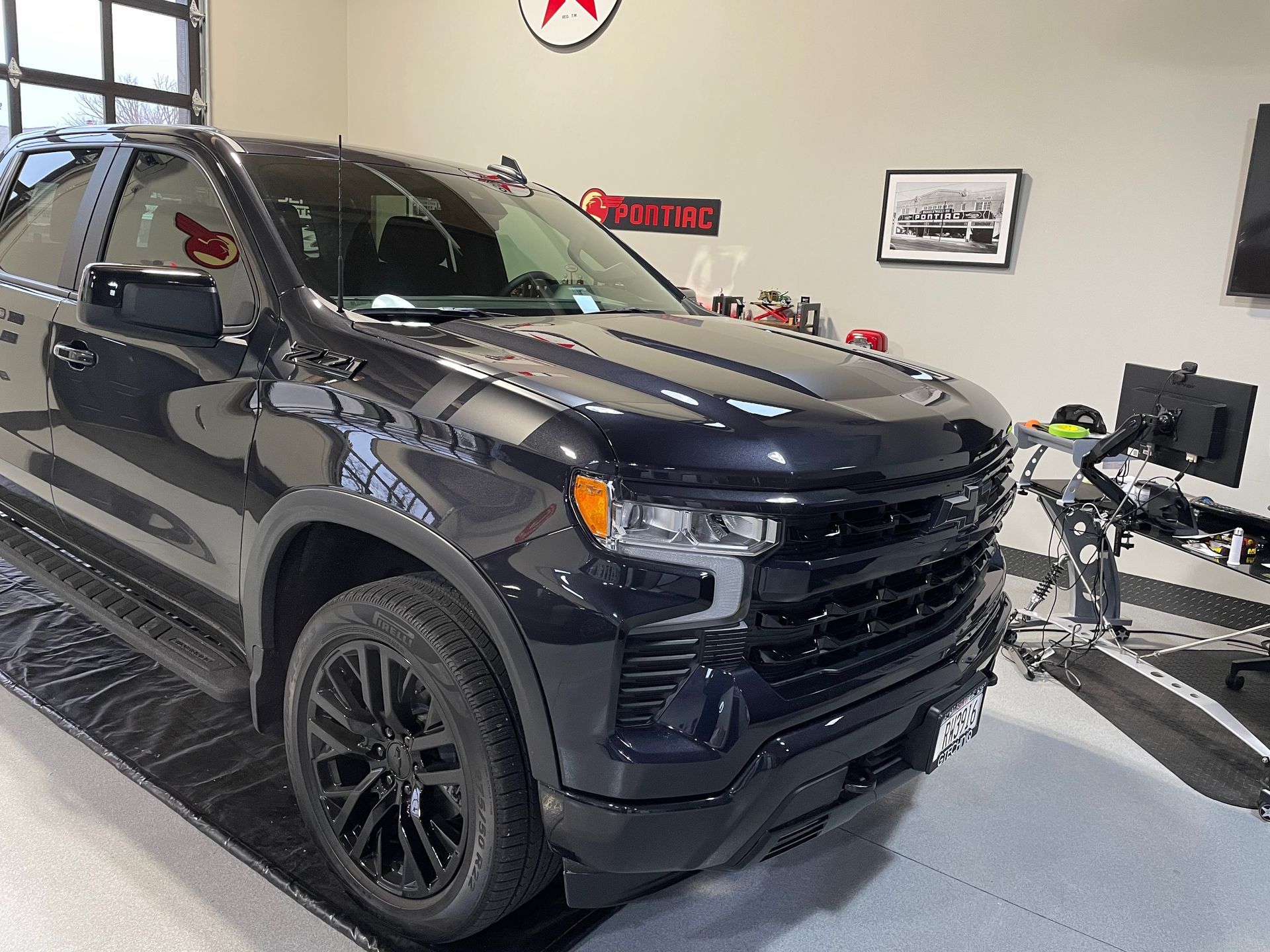 Dark blue Chevrolet Silverado pickup truck parked in a garage.