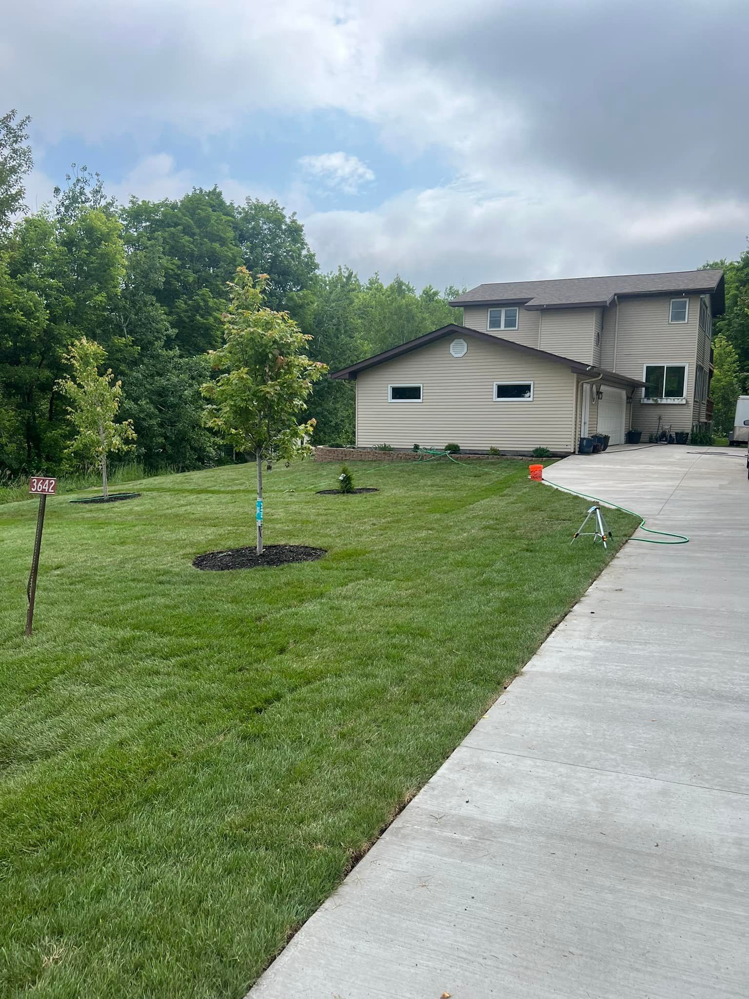 A house with a lot of grass and trees in front of it.