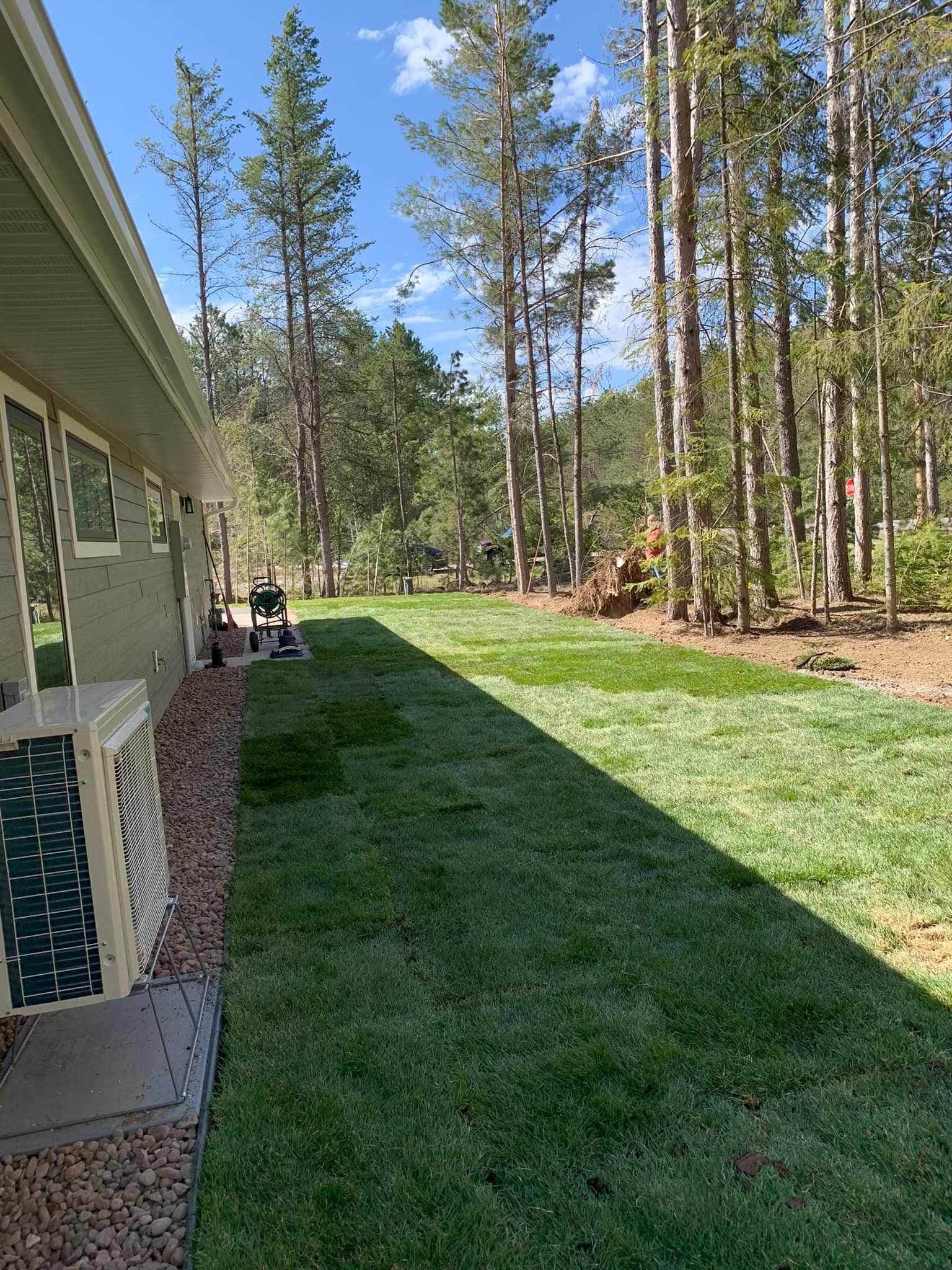 A house with a lush green lawn and trees in the background.