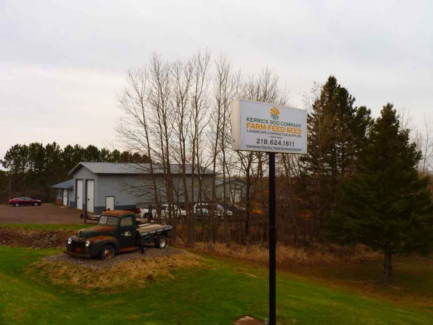 An old truck is parked in front of a sign that says service center