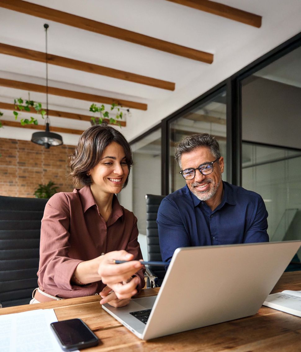 Business professionals discussing financial solutions on laptop — Ovation tax consultation