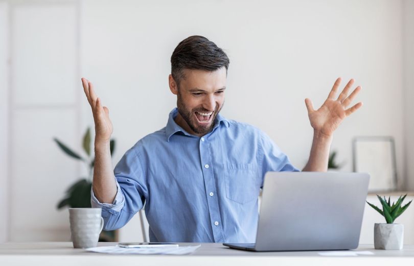 Man celebrating successful tax relief results online — Ovation Tax Group client result