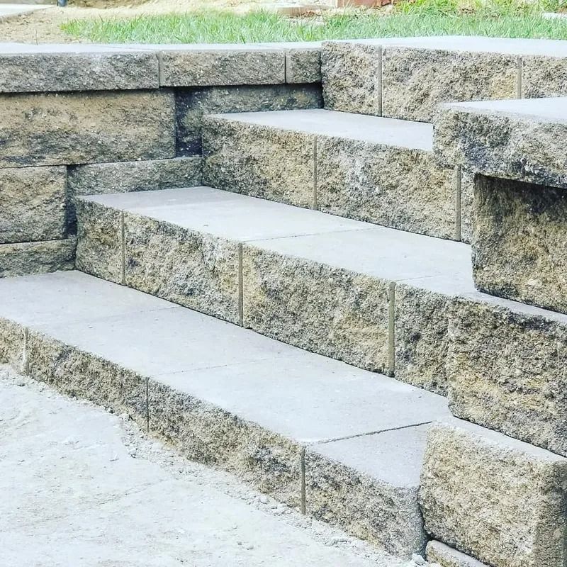 Stone steps with light gray treads built into a retaining wall outdoors
