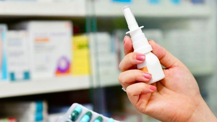 Allergies — Pharmacist Holding Nasal Spray Medicine and Capsule Pack in Yorba Linda, CA