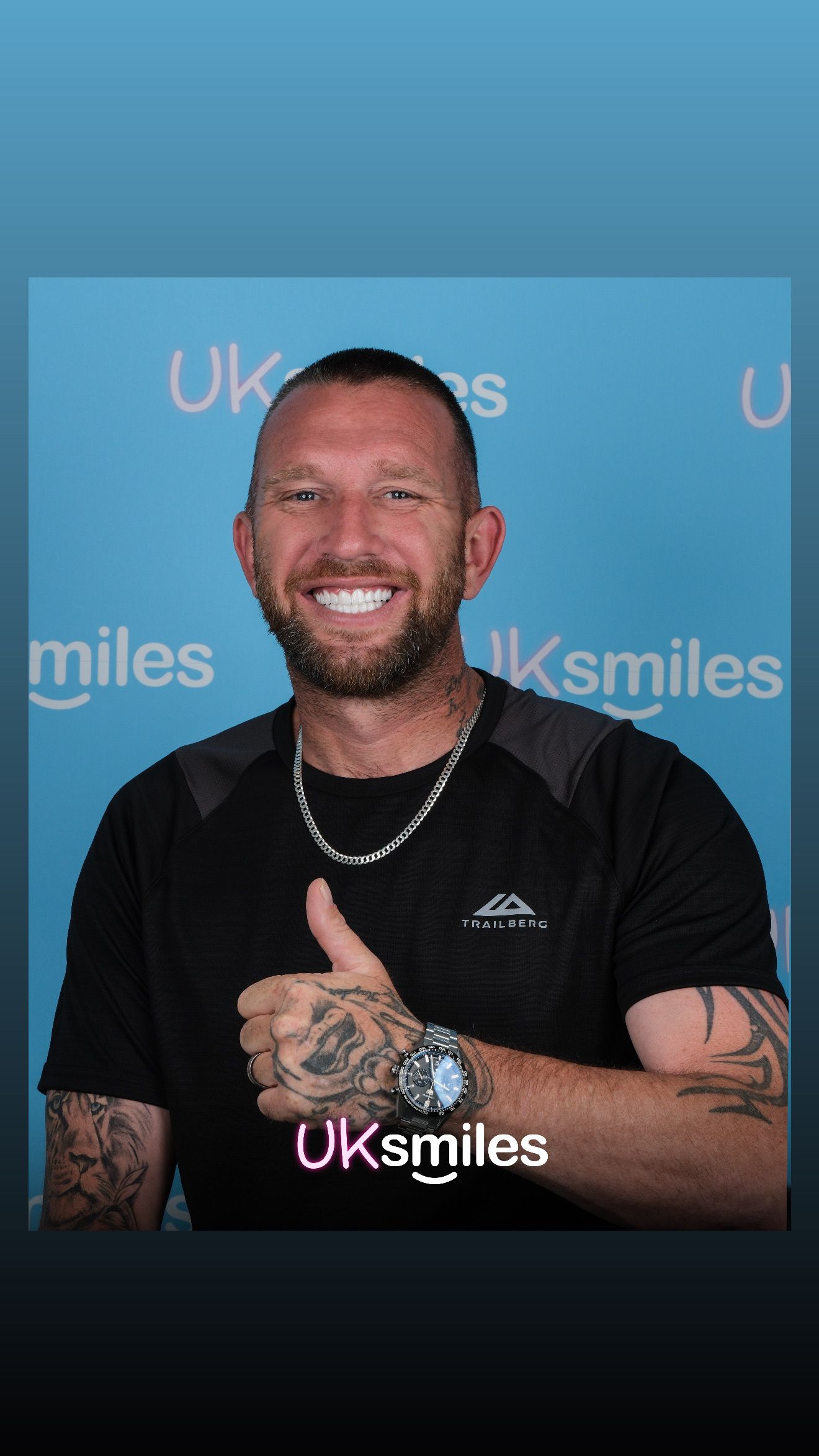 Man with tattoos giving a thumbs up, smiling at the camera; on a blue background with the logo