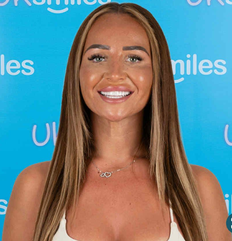 Woman with long brown hair, highlights, a white top, and a necklace smiles. Bright background with text.