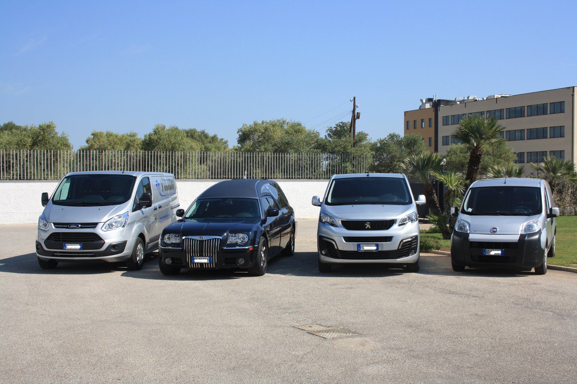 un carro funebre e dei furgoni