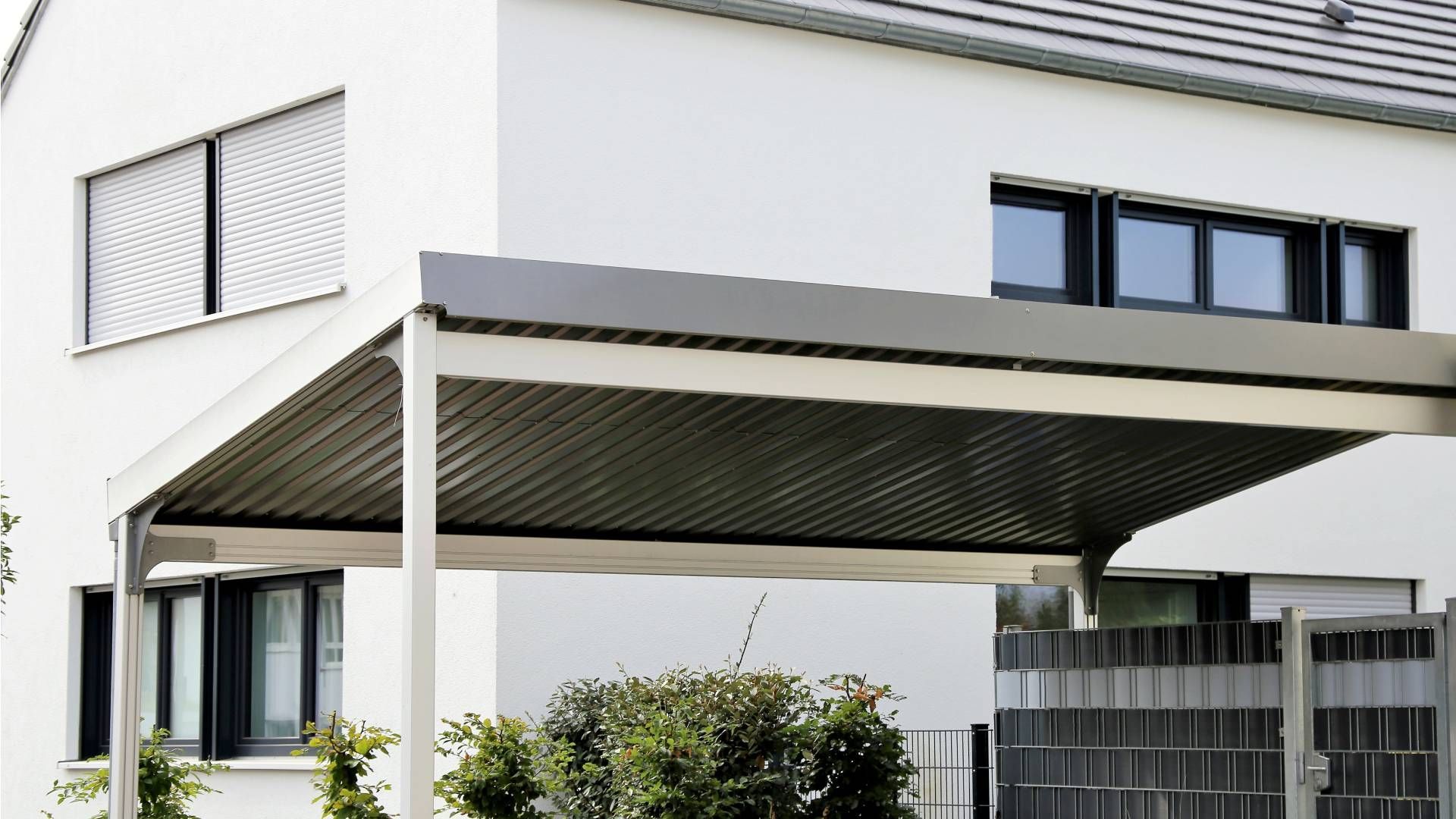 A white house with a carport in front of it