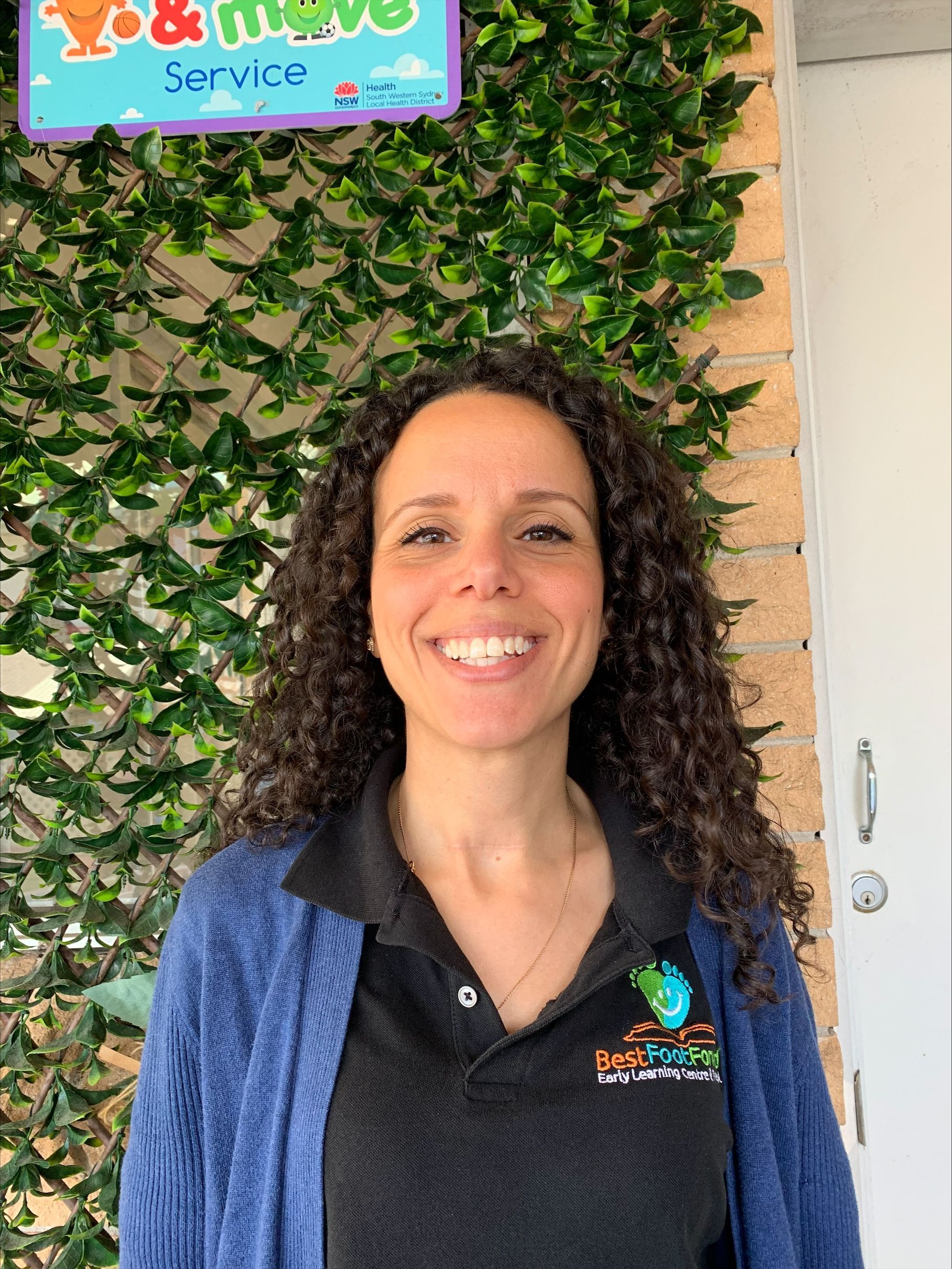 The woman owner is smiling in front of a sign that says service