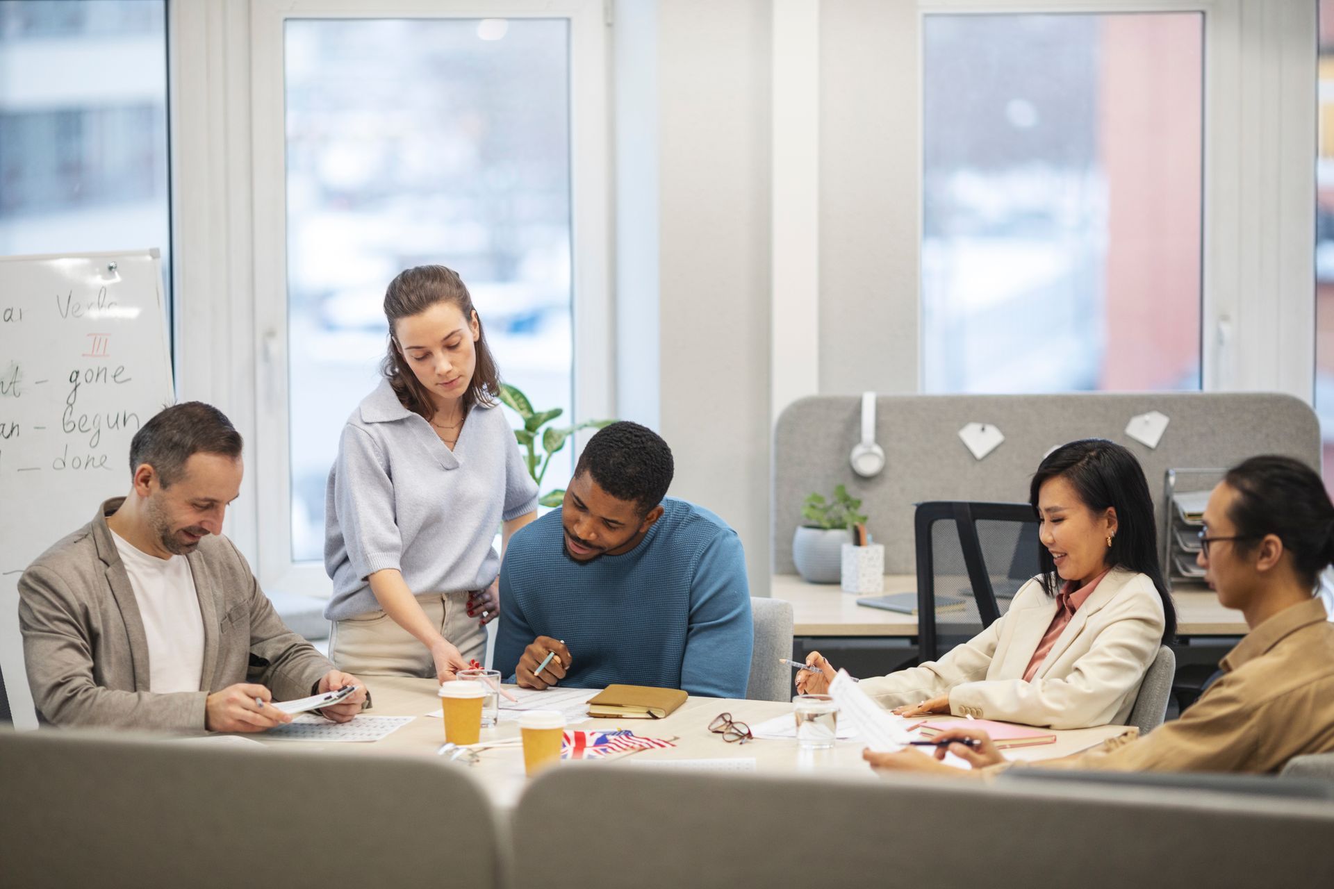 Group of people reviewing documents at a table in an office setting.
