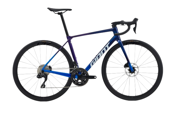 Bicicleta eléctrica gris con guardabarros, portabultos y frenos de disco.