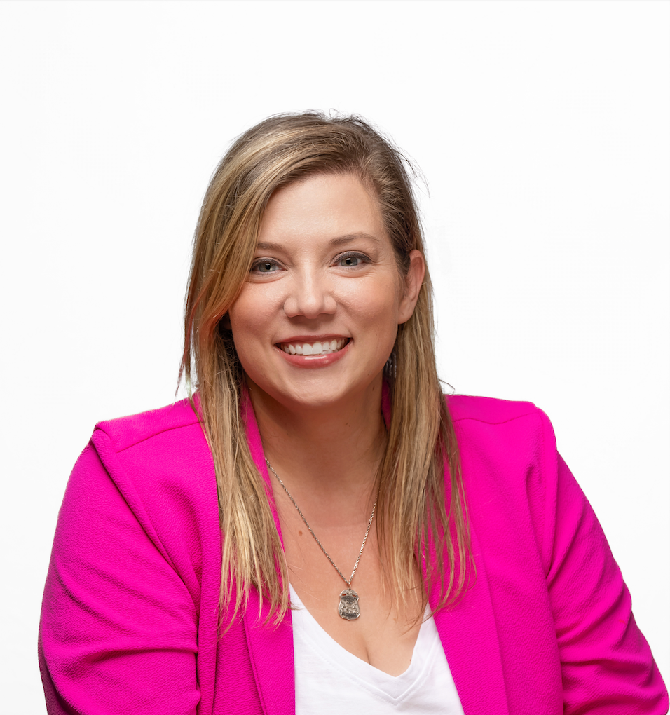 Woman with blonde hair in a pink blazer smiles at the camera against a white background. Woman with blonde hair in a pink blazer smiles at the camera against a white background.