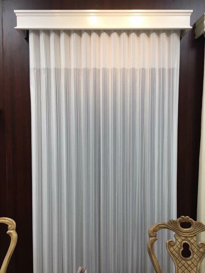 White sheer curtains with a pleated top, under a decorative white valance.