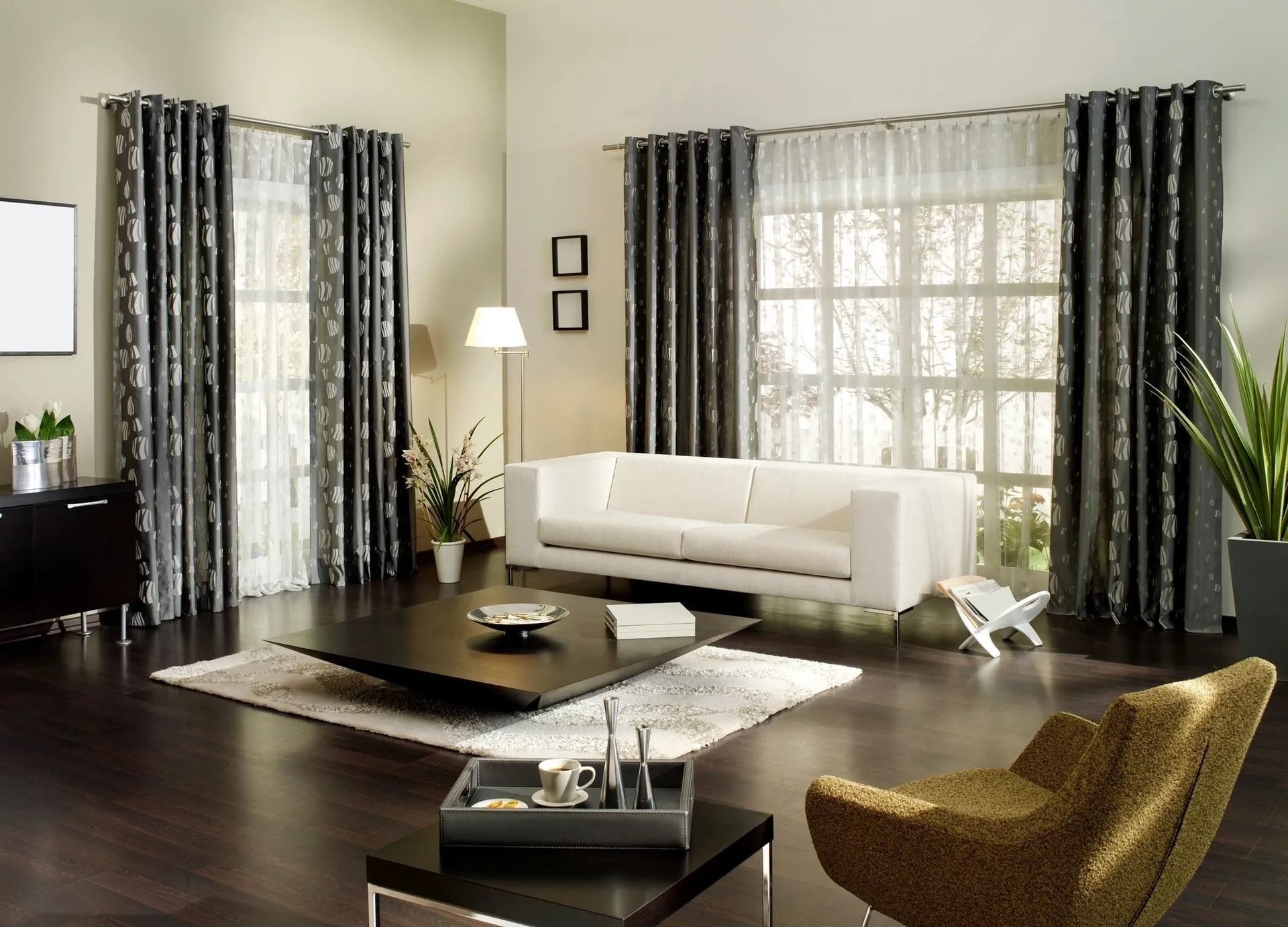 Living room with white sofa, patterned curtains, dark furniture, and a rug.