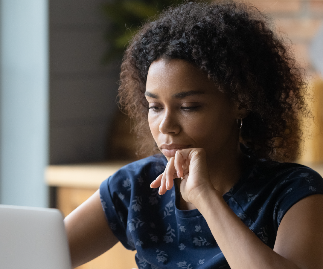 A woman is sitting in front of a laptop computer.