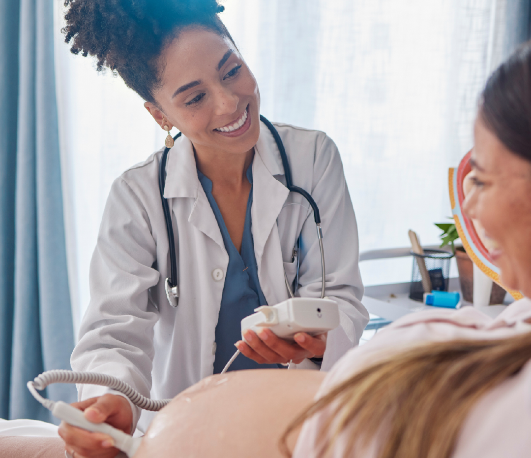 A pregnant woman is getting an ultrasound from a doctor.