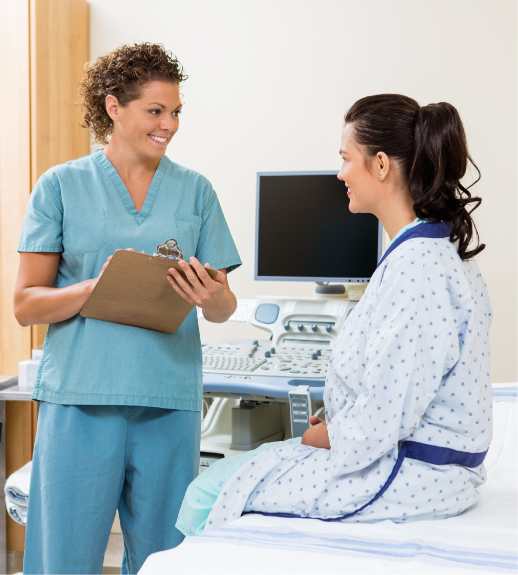 A nurse is talking to a patient who is sitting on a bed